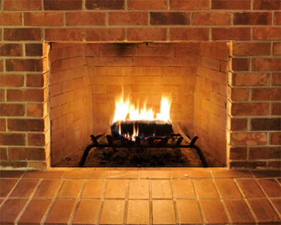 Stock Image-lit brick fireplace - New Buck Chimney Services